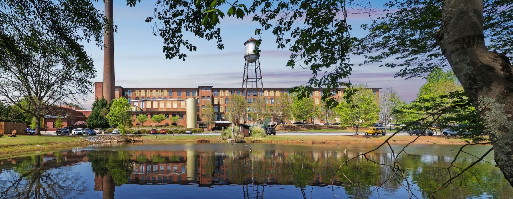 a body of water with trees in front of a building
